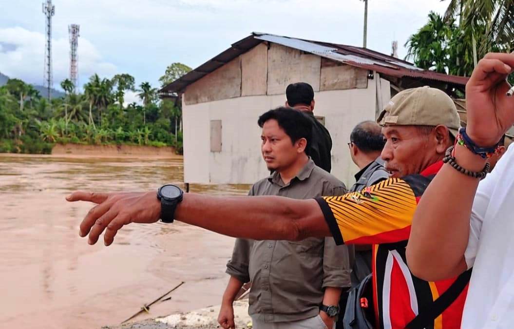 Orang tua Andika Mandala Darma, memberi penjelasan detik-detik rumah kediamannya di ludes dibawa arus Batang Anai kepada Ketua KONI Sumbar Hamdanusdan rombongan, Jumat (28/11/2025). (Foto KONI Sumbar)
